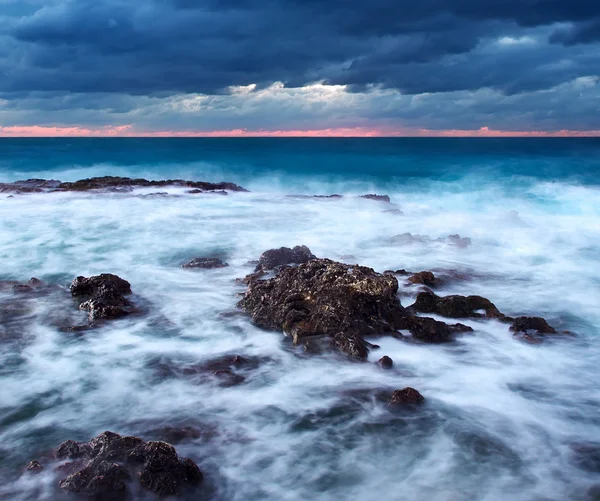 Pedra do mar e céu brilhante durante o pôr do sol — Fotografia de Stock