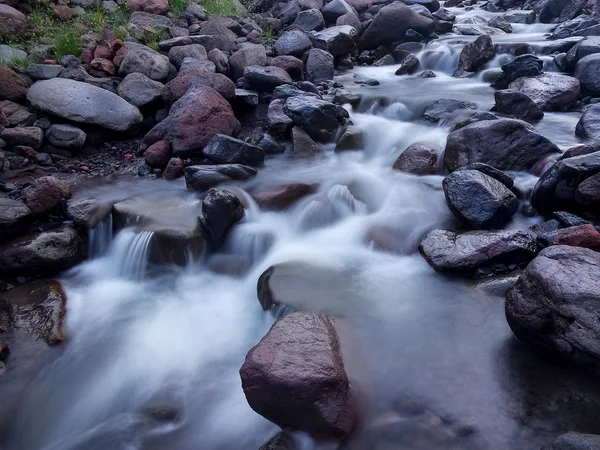Karanlık taşlar arasında hızlı Nehri. — Stok fotoğraf