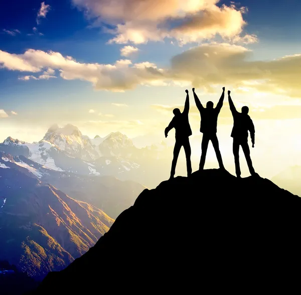 Silhouette of the team on the peak of mountain Stock Photo