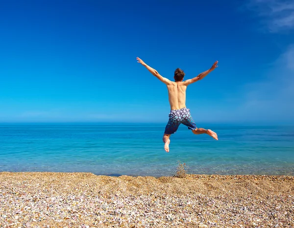 L'uomo salta sulla spiaggia — Foto Stock