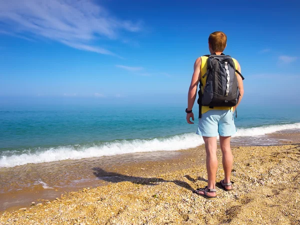 Bakifrån av en man med ryggsäck på stranden — Stockfoto