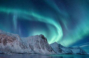 Norveç 'te Aurora Borealis. Dağların üzerinde yeşil kuzey ışıkları. Aurora ile gece kışı manzarası. Norveç 'te doğal fenomen.
