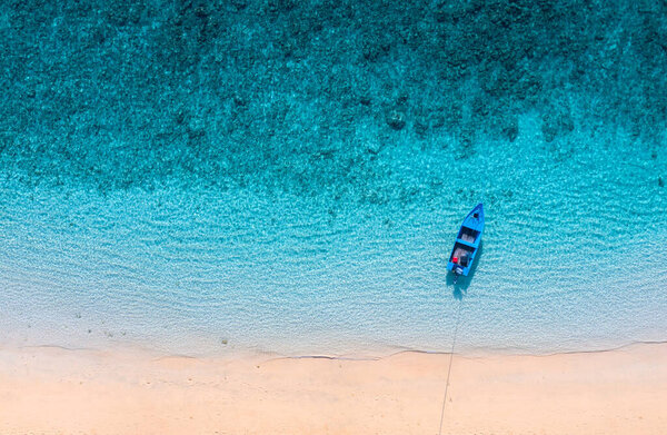 Boat near the beach. Blue water background from top view. Summer seascape from air. Aerial landscape. Travel image