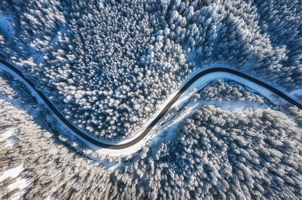 Havadan gelen doğal kış manzarası. Kış zamanı yol ve ormanın hava manzarası. Kış soğuğu. Orman ve kar. Fotoğraf yüksek çözünürlükte..