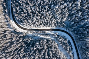 Havadan gelen doğal kış manzarası. Kış zamanı yol ve ormanın hava manzarası. Kış soğuğu. Orman ve kar. Fotoğraf yüksek çözünürlükte..