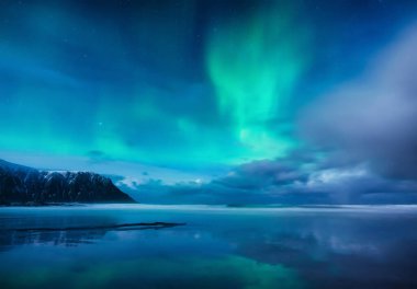 Aurora Borealis. Norveç, Lofoten Adaları 'ndaki Skagsanden plajı. Kuzey ışığı. Su yüzeyindeki yansımalar. 