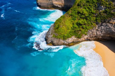 Dalgalar ve kayalar yukarıdan bakıldığında arka plan olarak görülür. Yukarıdan mavi su arka planı. Havadan gelen yaz deniz manzarası. Endonezya 'daki Bali Adası. Seyahat - resim