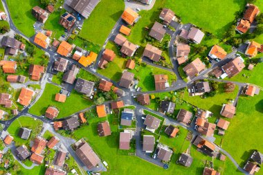 Aerial view of the village and the streets. View of the countryside from a drone. Roofs of houses with shingles. Landscape from a drone in the summertime clipart