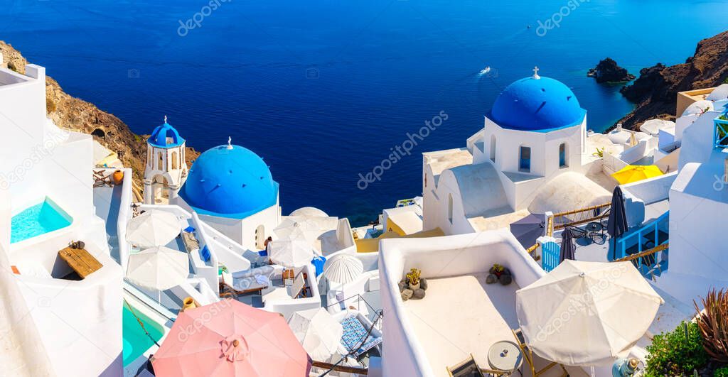 Santorini, Greece. Panoramic view of traditional houses in Santorini. Small narrow streets and rooftops of houses, churches and hotels. Oia village, Santorini Island, Greece.