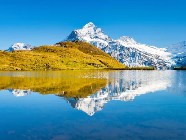 Yüksek dağlar ve gölün yüzeyindeki yansıma. Göllü Dağ Vadisi. Yaz aylarında dağlık arazide manzara. Fotoğraf yüksek çözünürlükte