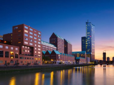 Rotterdam, Hollanda. Şehir merkezinin manzarası. Tekneler ve gemiler için körfez ve rıhtım. Panoramik manzara. Akşamları şehir manzarası. Gökdelenler ve binalar.
