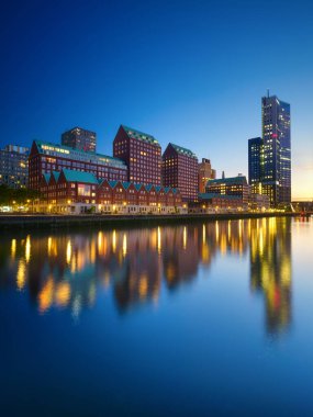 Rotterdam, Hollanda. Şehir merkezinin manzarası. Tekneler ve gemiler için körfez ve rıhtım. Panoramik manzara. Akşamları şehir manzarası. Gökdelenler ve binalar.