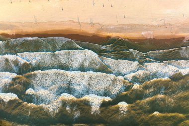 Geniş sahil ve dalgaların hava manzarası. Gün batımında bir dronun deniz manzarası. Kumlu bir deniz kıyısı. Deniz ve sahil. Yukarıdan kumsalın manzarası.