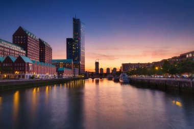 Rotterdam, Hollanda. Şehir merkezinin manzarası. Tekneler ve gemiler için körfez ve rıhtım. Panoramik manzara. Akşamları şehir manzarası. Gökdelenler ve binalar.
