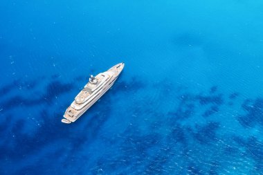 Gök mavisi suyu olan bir körfezde çok katlı bir yat. Yaz tatilleri ve gemide geziler. Deniz taşımacılığının havadan görüntüsü. Lüks bir hayat. Yaz tatili. İHA 'dan deniz burnu.