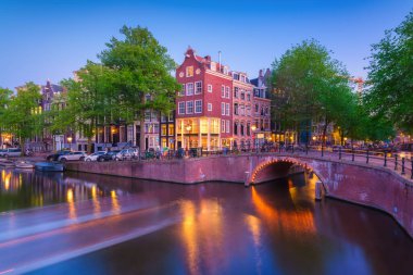 Amsterdam, Hollanda. Gün batımında ev ve köprü manzarası. Meşhur Hollanda kanalları ve köprüleri. Akşamları şehir manzarası. Seyahat fotoğrafçılık.