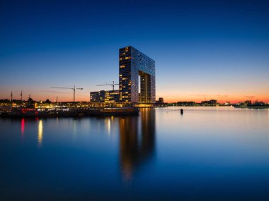 Amsterdam, Netherlands. A cityscape in the evening. A skyscraper and business center near the water in the bay. Architecture of the Netherlands. Travel photography.