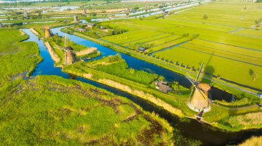 Yel değirmeninin havadan görünüşü. Kinderdijk Ulusal Parkı. Tarım için suyu olan kanallar. Tarlalar ve çayırlar. Havadan manzara..