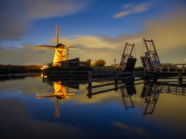 Hollanda 'daki Kinderdijk Ulusal Parkı. Alacakaranlıkta yel değirmenleri. Tarihi bir yerde doğal bir manzara. Su yüzeyindeki yansımalar. Hollanda kanalları. UNESCO Dünya Mirası Alanı.