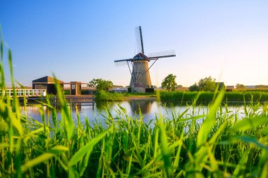 Hollanda 'daki Kinderdijk Ulusal Parkı. Gündüz vakti yel değirmenleri. Tarihi bir yerde doğal bir manzara. Su yüzeyindeki yansımalar. Hollanda kanalları. UNESCO Dünya Mirası Alanı.