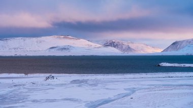 İzlanda 'daki dağların panoramik manzarası. Güçlü rüzgarlar. Fırtına sırasında vahşi manzara ve karanlık. Kış zamanı İzlanda 'nın doğasının bir görüntüsü.
