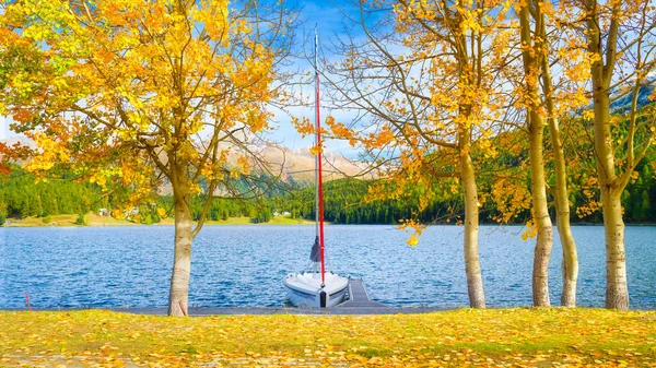 湖畔の秋の風景 黄色の葉を持つ木 山の湖の岸にボート 秋の時間に自然の風景 休日スポット — ストック写真
