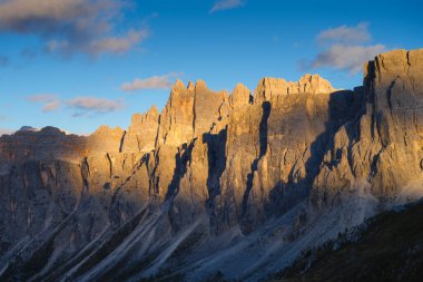 Dolomit Alpleri, İtalya. Gün batımında dağların ve yüksek uçurumların manzarası. Yüksek keskin kayalar ve yumuşak güneş ışığı. Doğa manzarası. Fotoğraf yüksek çözünürlükte.