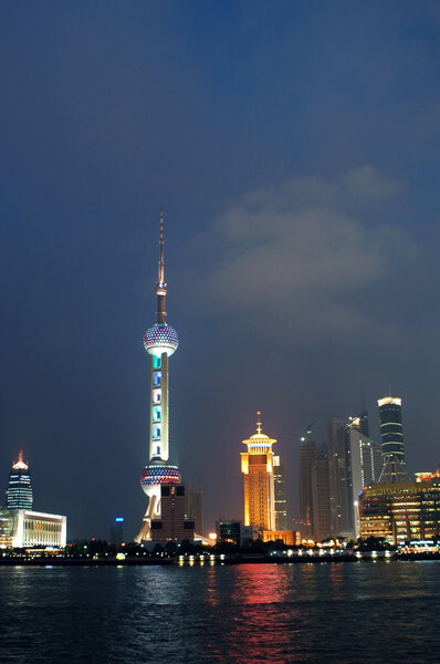 China, Shanghai city. Beautiful night scenery of Pudong area with modern skyscrapers, famous TV tower and ships at Huangpu river.