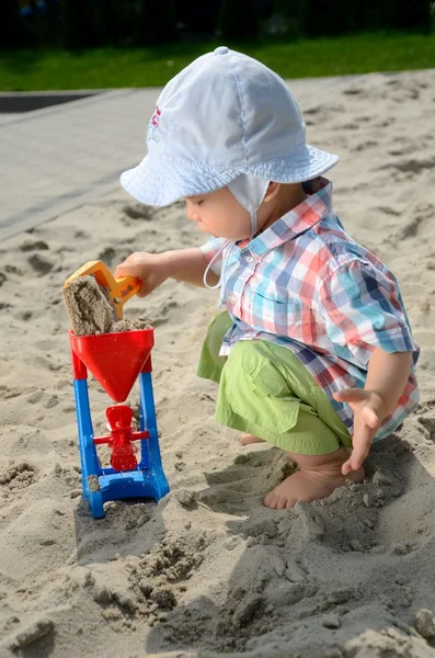 Baby boy in sandpit