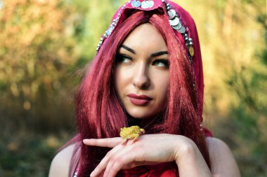 Ormanda kadın model, gündüz fotoğraf çekimi. Kızıl saçlı genç kadın, kurbağalı prenses..