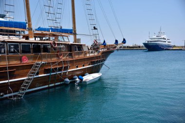 Rodos, Yunanistan - 19 Haziran 2022: Küçük gemileri ve büyük yatları olan Rodos limanı. Ünlü tatil beldesi.