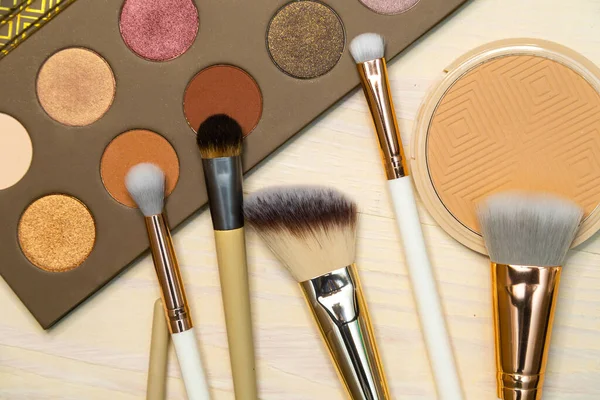 Nude Makeup Products Powder Brushes Palette wood background