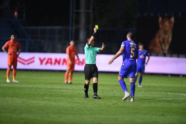 Thanyaburi-Pathumthani-6 NOV 2021: Warinthon sassadee hakemi bgpu ile Tayland 'daki Leo Stadyumu' nda defnedilmeye karşı bgpu arasında sarı kart gösteriyor
