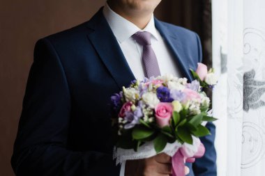 The man puts on a jacket. The groom in a jacket.
