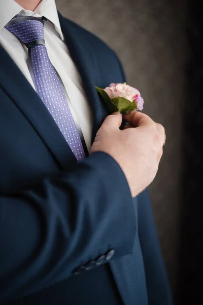 The man puts on a jacket. The groom in a jacket. 