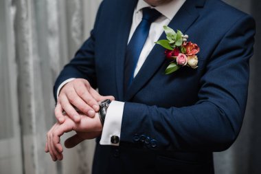 The man puts on a jacket. The groom in a jacket. 