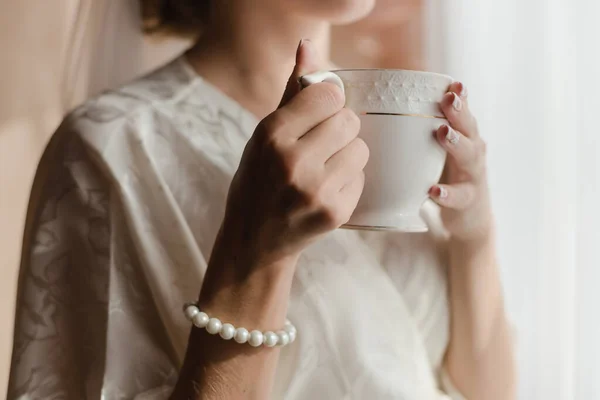 Girl with a cup of tea. Bride with a cup of coffee.