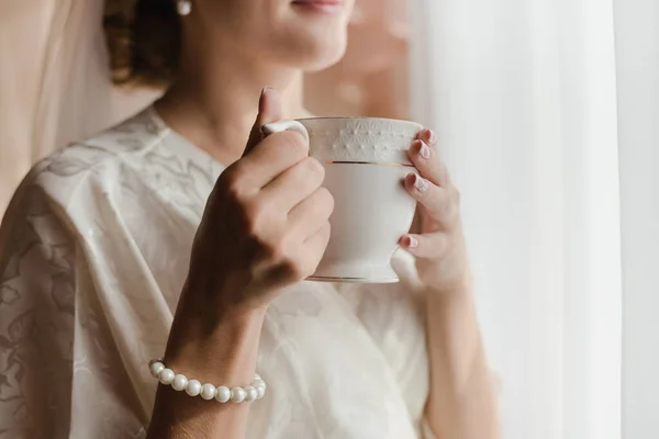 Girl with a cup of tea. Bride with a cup of coffee.