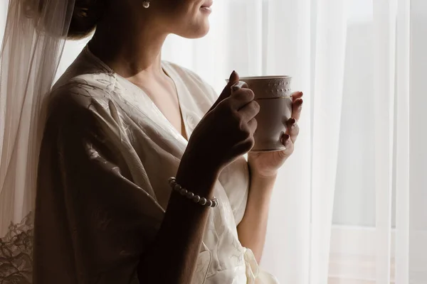 Girl with a cup of tea. Bride with a cup of coffee.