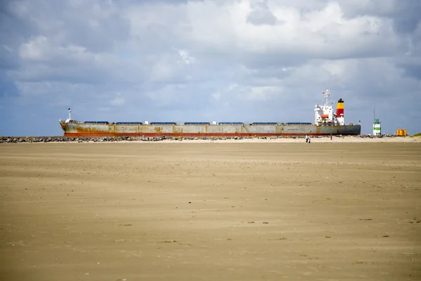 Cargo ship passing a beach on her way to the sea — Stock Photo, Image