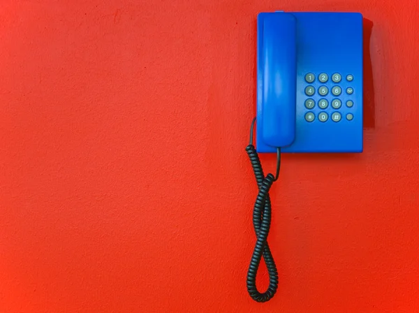 Teléfono interno azul en una pared roja —  Fotos de Stock