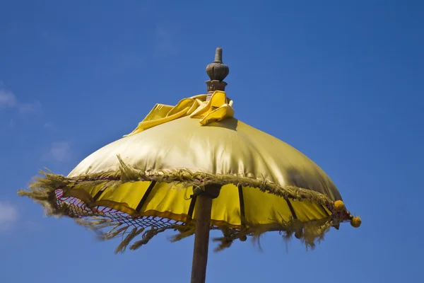 Balinese ceremonial pajeng (umbrella) against a blue sky — Stock Photo, Image