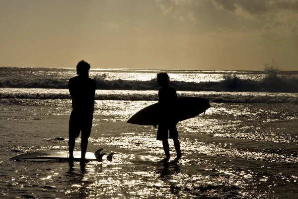Uluwatu beach, bali günbatımında Surfers — Stok fotoğraf