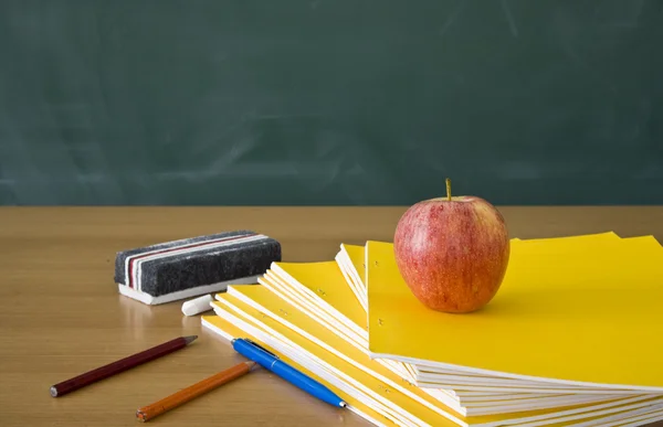 Bodegón de un escritorio de profesores con una pizarra en el fondo — Foto de Stock