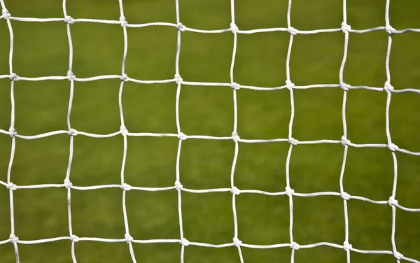 Fotbollsmål netto med fotboll fältet bakgrund — Stockfoto