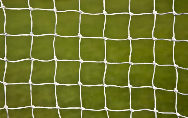 Red de portería de fútbol con un fondo de campo de fútbol —  Fotos de Stock