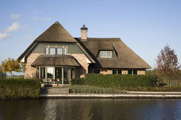 Nieuw gebouwd huis aan de waterkant in traditionele Nederlandse landelijke stijl — Stockfoto