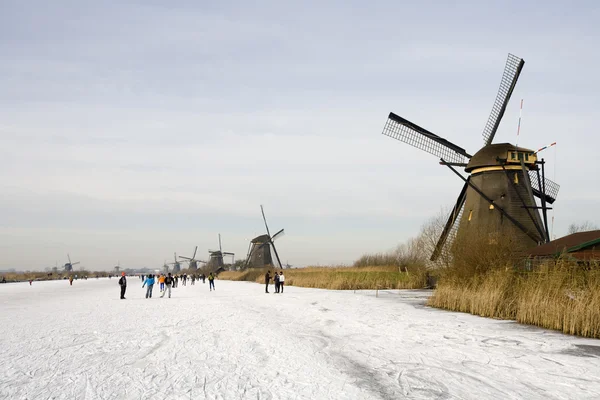 Escena de patinaje con molinos de viento históricos holandeses en Kinderdijk — Foto de Stock