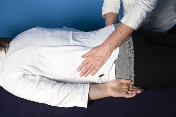 A young woman is getting a reiki treatment — Stock Photo, Image