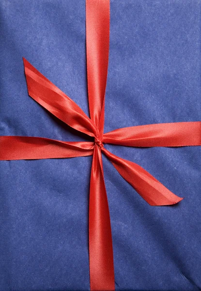 Christmas present wrapped in red ribbon — Stock Photo, Image